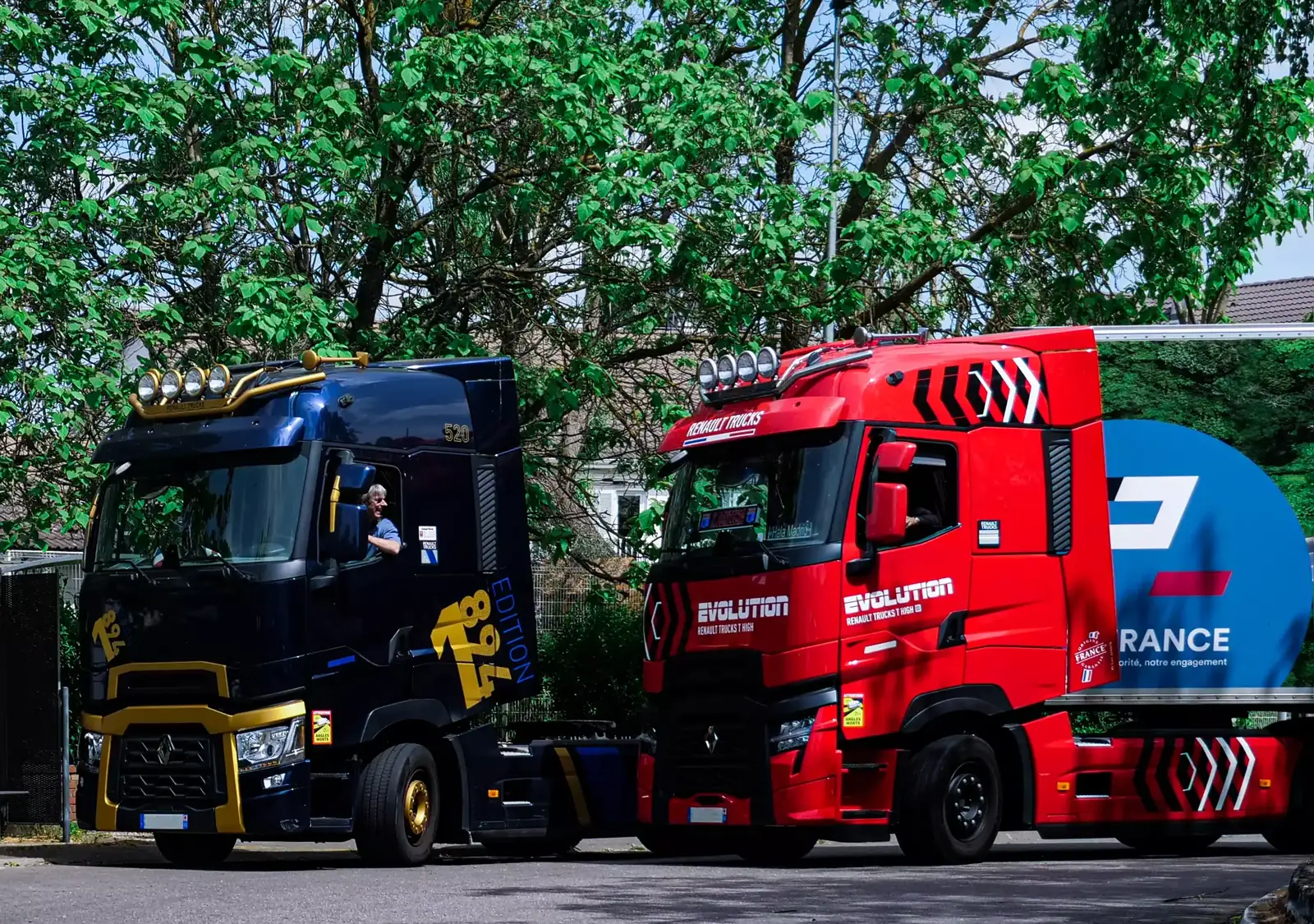 Deux tracteurs routiers aux couleurs de TPL France, l’un bleu nuit, l’autre rouge